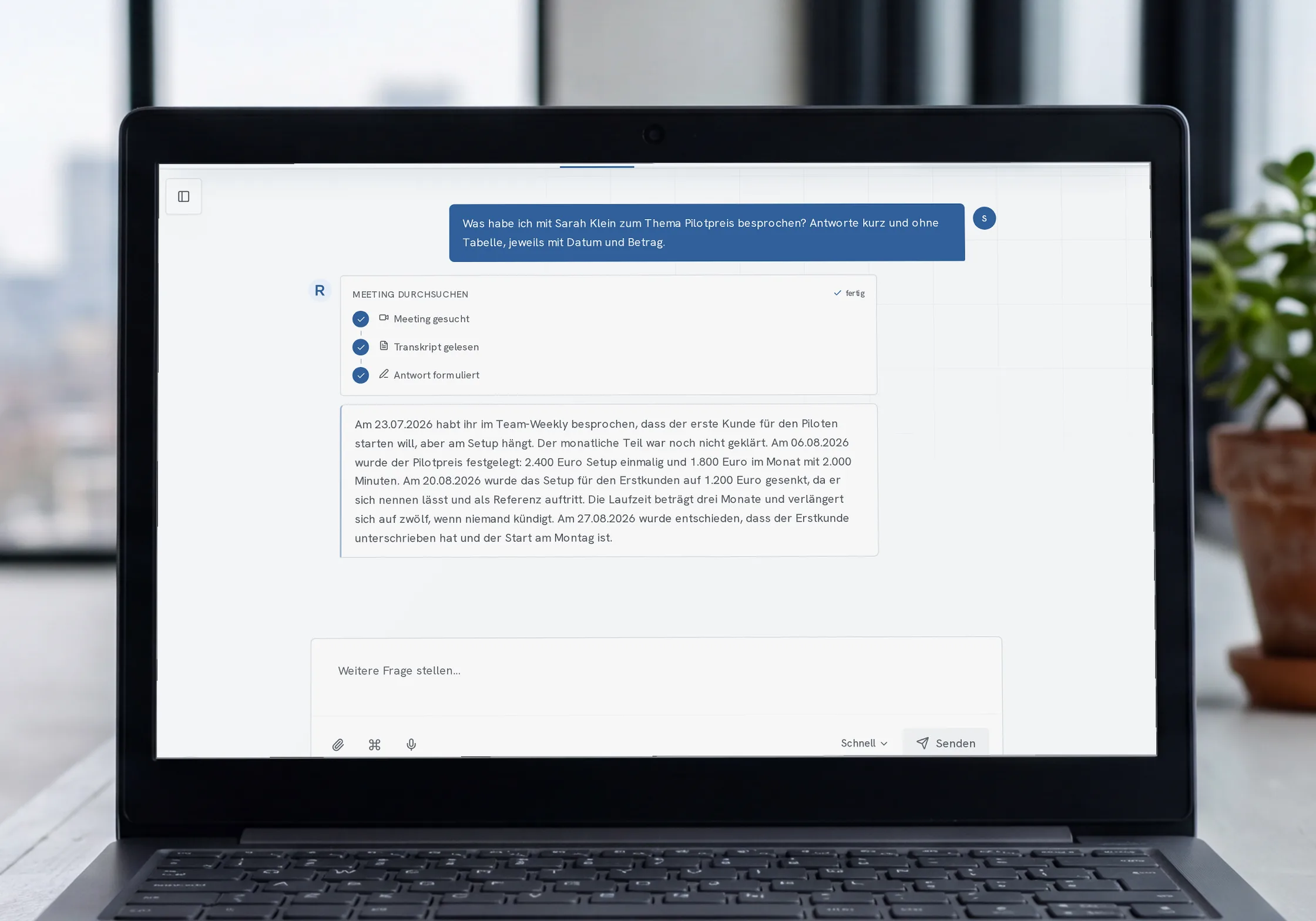 Laptop auf einer Fensterbank vor einer Stadtansicht; auf dem Schirm beantwortet der Raven-Assistent eine Frage mit Daten und Beträgen